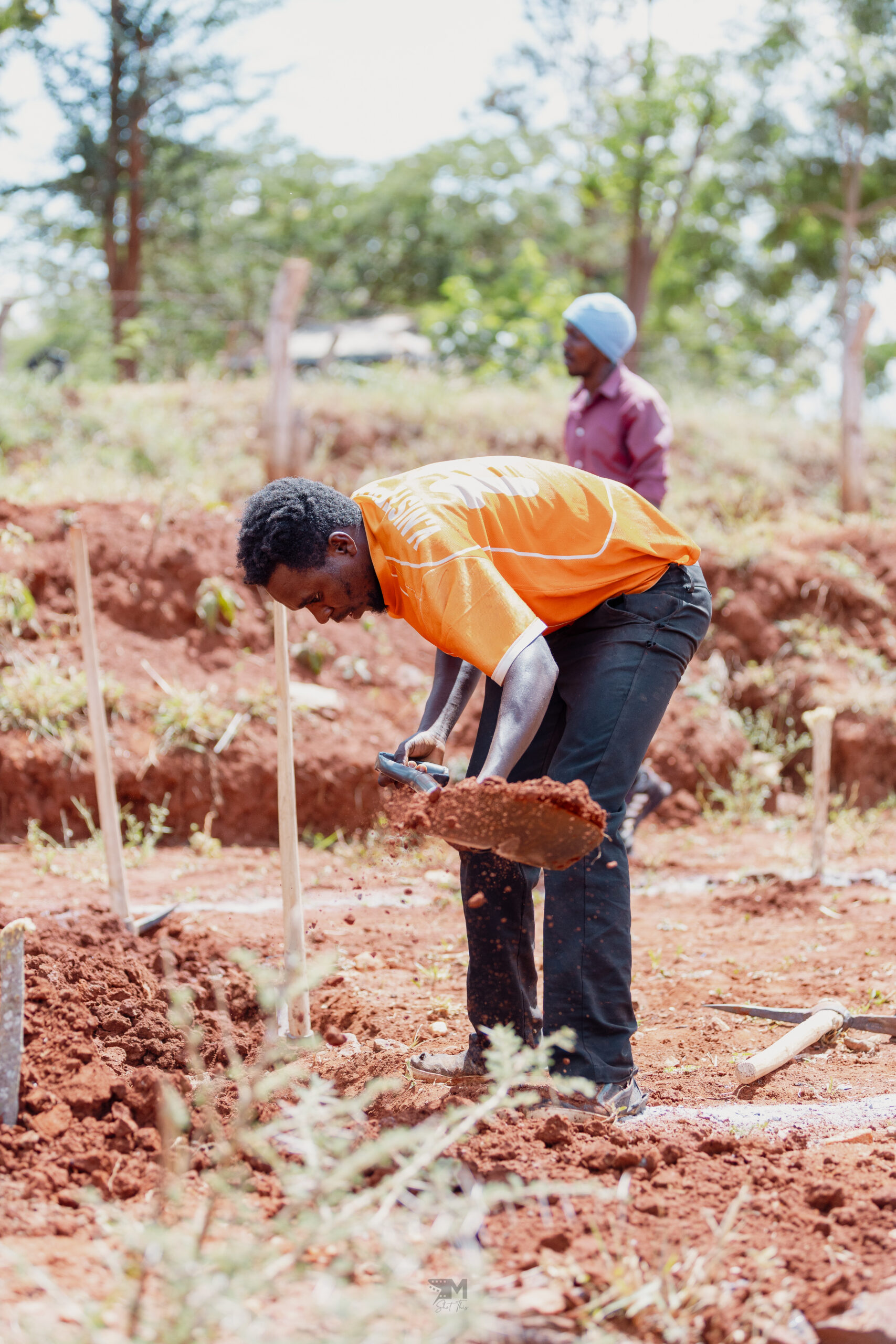A local young man taking part in the digging of a water pan.