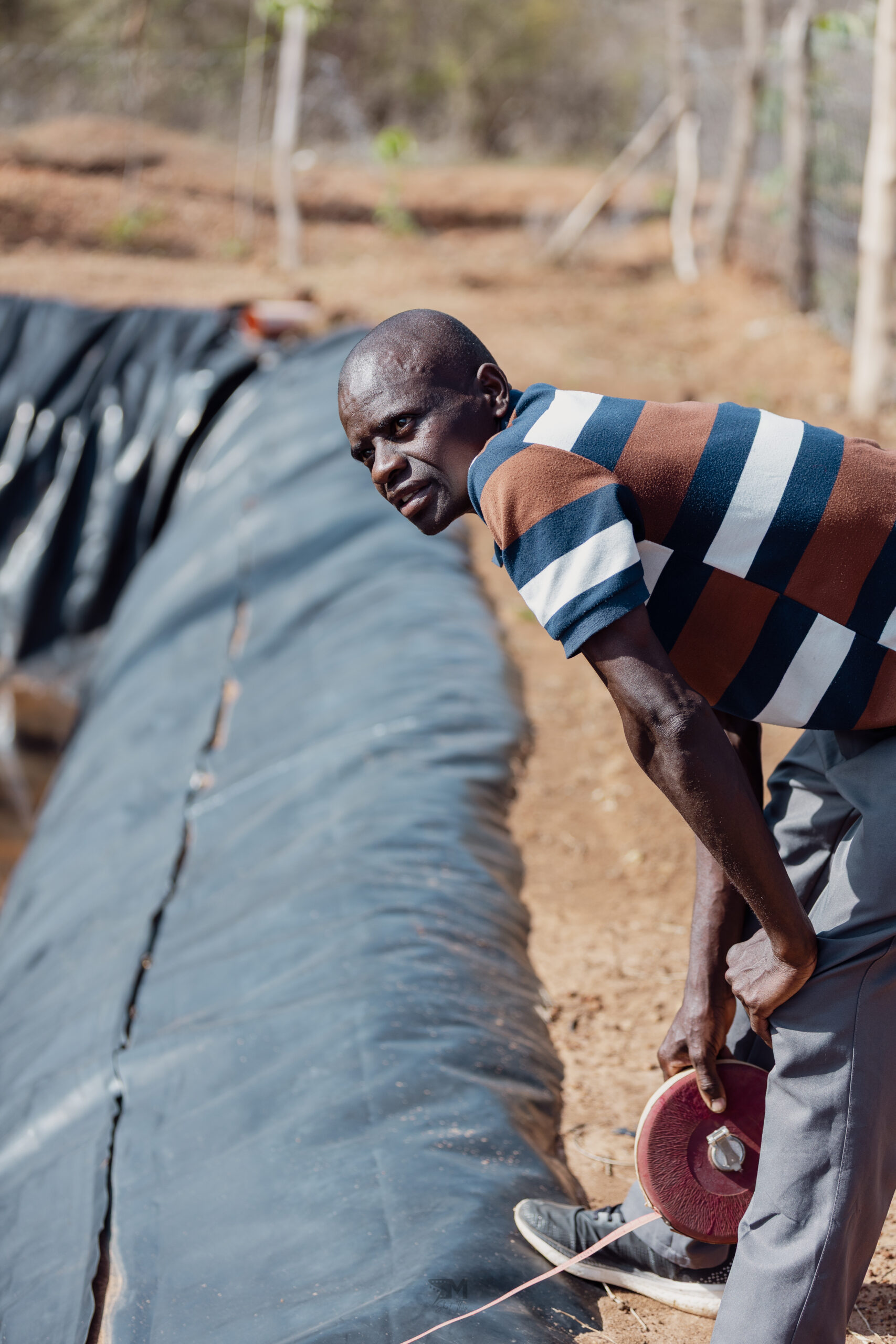 Our water pan expert in Machakos assesses the development of a water pan in construction.